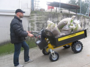 Brouette électrique avec plateau transportant des sacs dans une pente